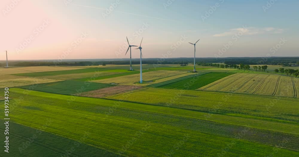 Aerial drone view of wind power turbines, part of a wind farm. Wind turbines on green field in countryside. Wind power plant. Aerial drone view of wind power turbines, part of a wind farm. Wind turbines on green field in countryside. Wind power plant.