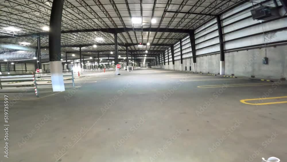 POV driving thru empty enclosed parking lot in the early morning; luxury parking lot with cart corrals for a big box store to keep its customers out of the weather and safe from crime POV driving thru empty enclosed parking lot in the early morning; luxury parking lot with cart corrals for a big box store to keep its customers out of the weather and safe from crime