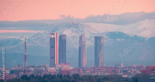 Timelapse of Madrid 5 towers skyline and snowy sierra mountain during sunrise photo