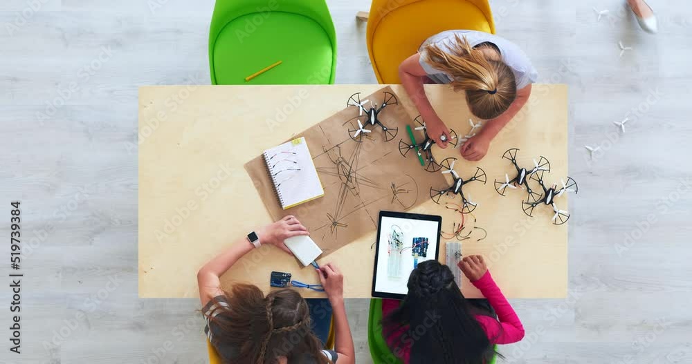 Smart students design drone from a creative sketch drawing. Testing and flying a drone with a remote control..Above view of diverse girl students learning together as a team in a classroom