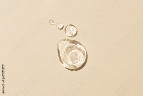 Glycerin gel texture. Transparent serum drop on beige background. Liquid gel moisturizer with bubbles macro photo