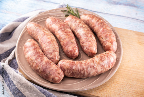 Composition with Polish white sausage, easter delicacy. Steamed white sausage on a plate, on a wooden background.
