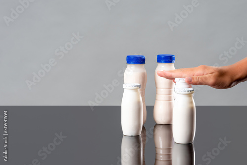 Hand over a bottle of probiotics, yogurts with bifidobacteria supplements. Dairy products to improve digestion and immunity. Probiotics and fruits for health. photo