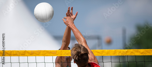 Athletic man jumping to make wall block at beach volleyball net. Horizontal sport theme poster, greeting cards, headers, website and app.