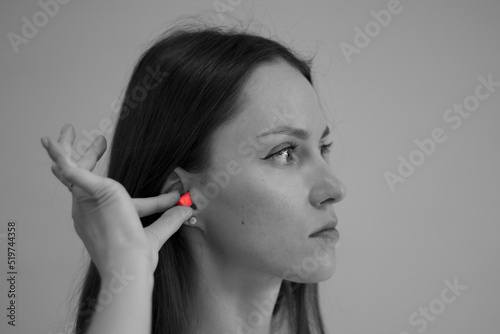 Canvas Print The woman takes earplugs out of her ears