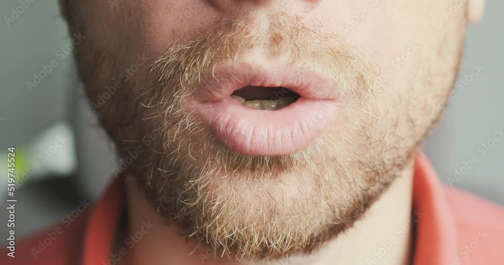 Face of an unshaven man exhales air through his mouth. Close-up ...