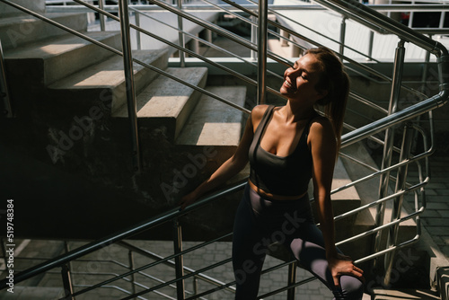 Portrait of young woman in sportswear resting during her workout in the city. Healthy habits.