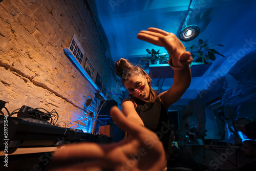 Photography Beautiful female DJ dancing to techno in a small club