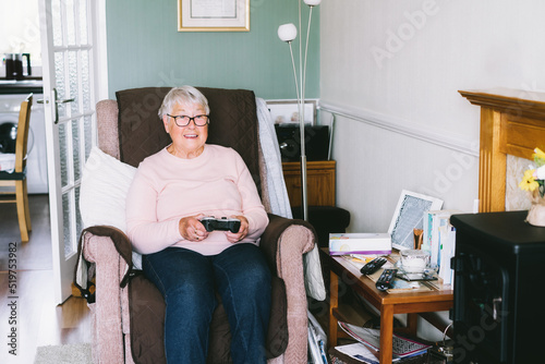 Emotional senior, mature woman looking at tv screen and using wireless controller, joystick gamepad playing video games at home. Fun on Retirement. Gaming hobby. Technology, entertainment industry.