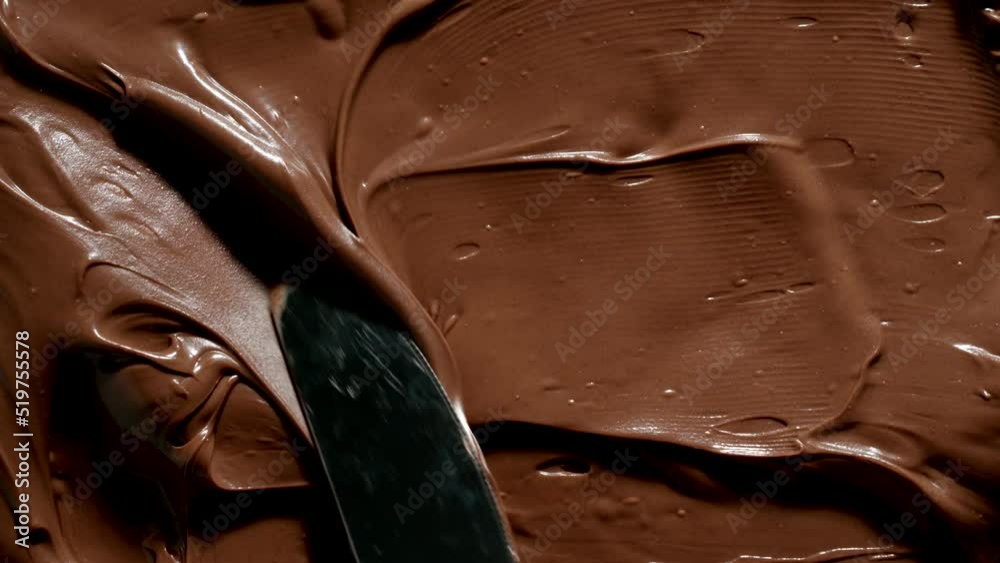 TOP VIEW: Knife spreads a chocolate paste