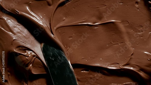 TOP VIEW: Knife spreads a chocolate paste photo