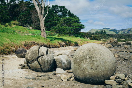 Large concretions on a sandy beach by the hill. Koutu boulders, Hokianga Harbour, New Zealand photo