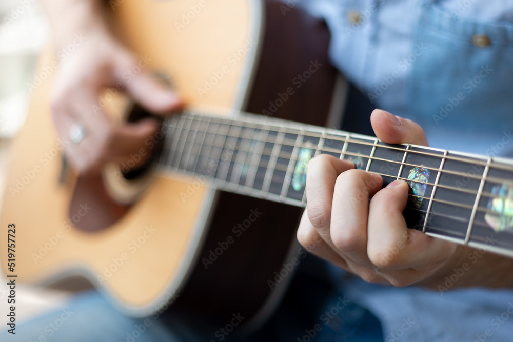 Close up of man's hands playing acoustic guitar. Musical instrument for recreation or hobby passion concept...
