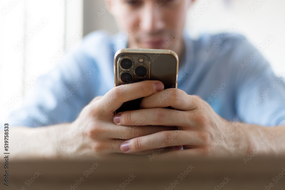 Man with a finger on the screen using a mobile phone in the office.