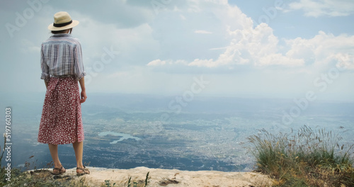 Woman traveler on mountain top lookig at city from height of flying flight. Epic concept of achievement, travel, opening up new horizons, experiences. Tirana city view from mountain Dajti, Albania photo