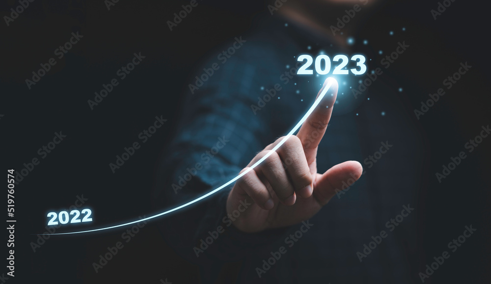 Businessman hand drawing for increasing arrow from 2022 to 2023 for preparation merry Christmas and happy new year concept. - obrazy, fototapety, plakaty 
