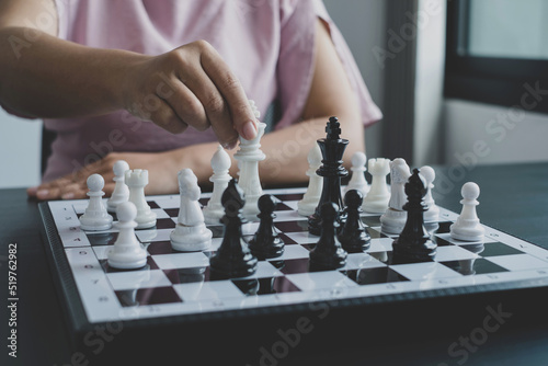 Hand of businesswoman moving, chess in competition shows leadership, followers, and business success strategies