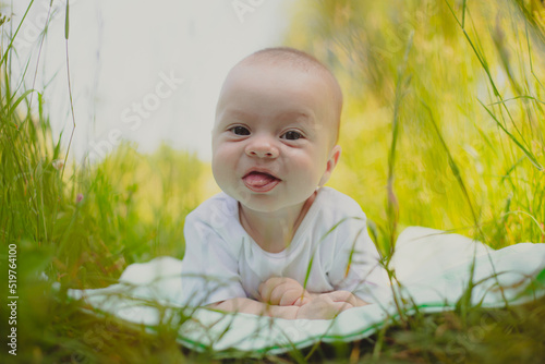 The baby is lying in the grass . A child in nature. Children's article.