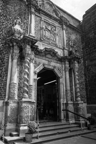 Facade detail view in black and white with spiralled columns, stone carvings and niches with saint statues of the old restored Basilica of Our Lady of Guadalupe in Mexico City, Central Mexico. photo