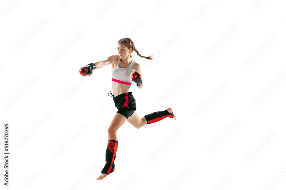 One sportive teen-girl, professional MMA fighter in action, motion isolated on white background. Concept of sport, competition, action, healthy lifestyle.