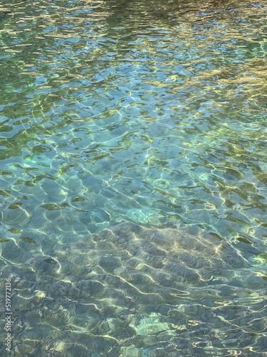 Sea glittering clear water surface in paradise turquoise lagoon.