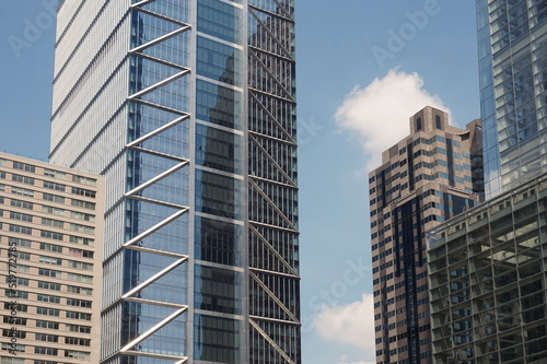 Cluster of Modern Skyscapers with Glass and Morter Against Blue Summer Sky