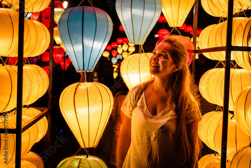 Turista mirando hermosas lámparas tradicionales de la ciudad de Hoi An, en Vietnam	 photo