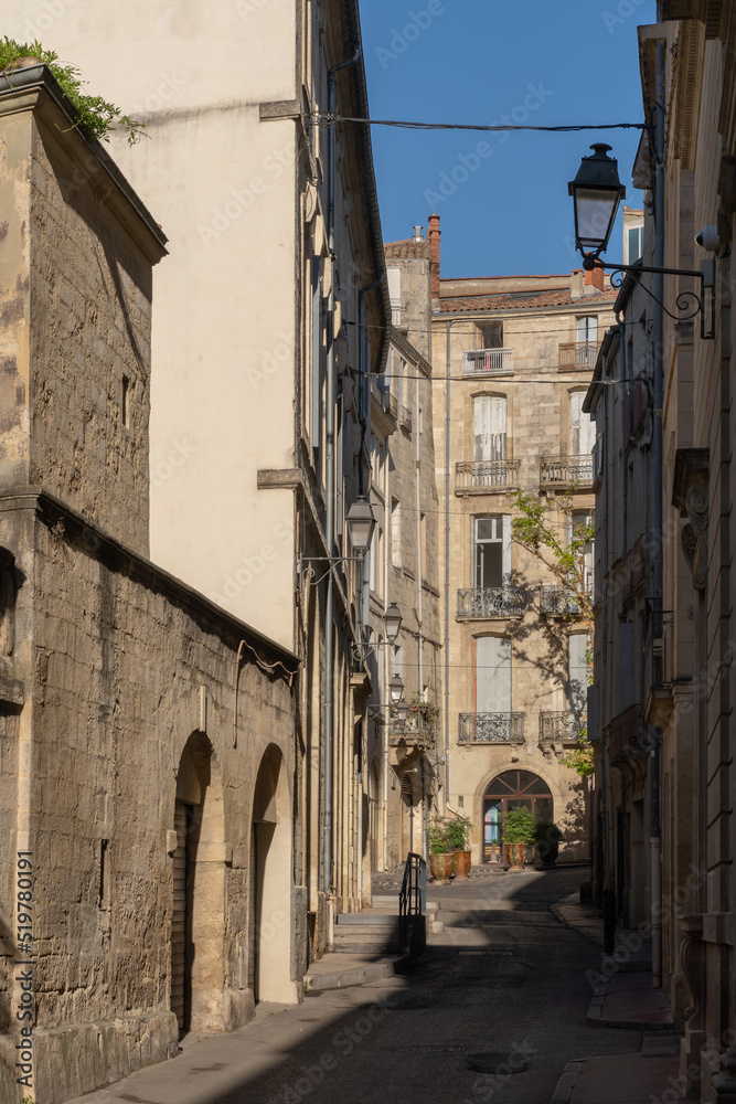 Scenic urban landscape view of ancient narrow alley with old buildings in the historic center of Montpellier, France	