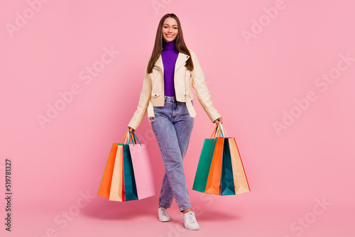 Full size photo of fashion cool young lady go shopping hold bags wear casual cloth shoes isolated on pastel pink color background