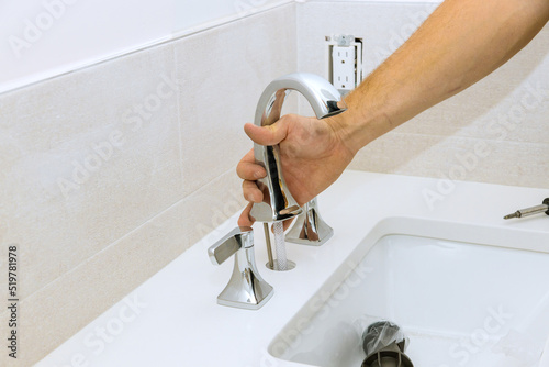 Bild auf Leinwand The plumber at work assembles and installs the water faucet in the bathroom
