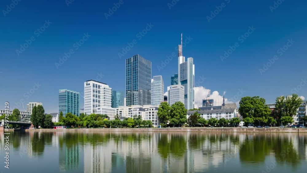 Frankfurt skyline time lapse, blue sky with clouds, office buildings and skyscraper in center with river in the foreground, Frankfurt am Main, Hessen, Germany Frankfurt skyline time lapse, blue sky with clouds, office buildings and skyscraper in center with river in the foreground, Frankfurt am Main, Hessen, Germany