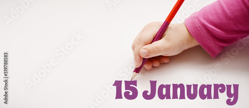 A child's hand writes 15 january in a lilac pencil. Banner with copy space