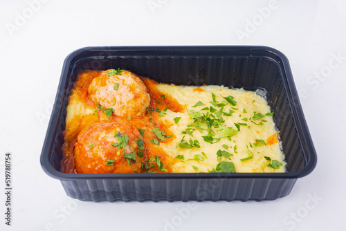 Food delivery to the office. Appetizing meatballs with mashed potatoes with caviar in a disposable bowl.