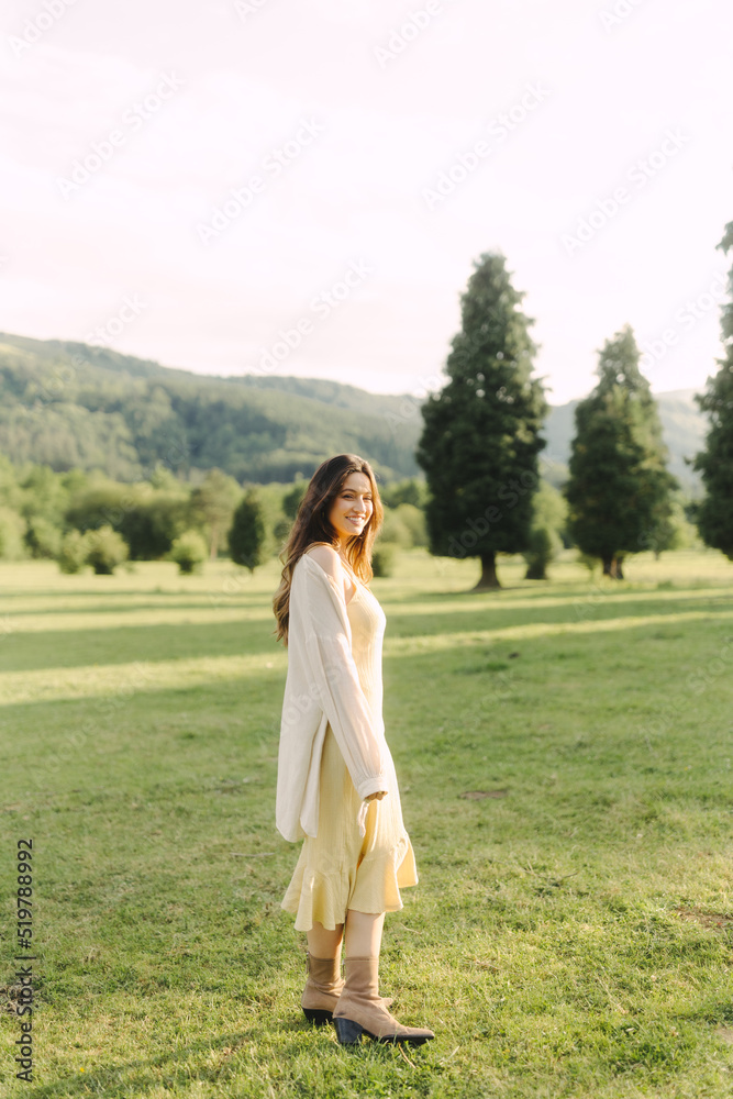 Young smiling woman standing in field in summer Young smiling woman standing in field in summer