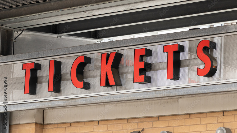 A red tickets sign above a ticket booth. 