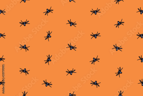 Creepy Halloween pattern with black spiders on orange background. Visual art. © Emir