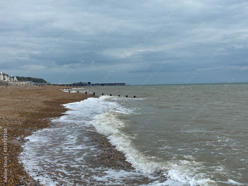 Hastings, East Sussex, UK - popular summer Hastings beach, waves hitting beach groynes, beach in St Leonards, Hastings, East Sussex south coast UK