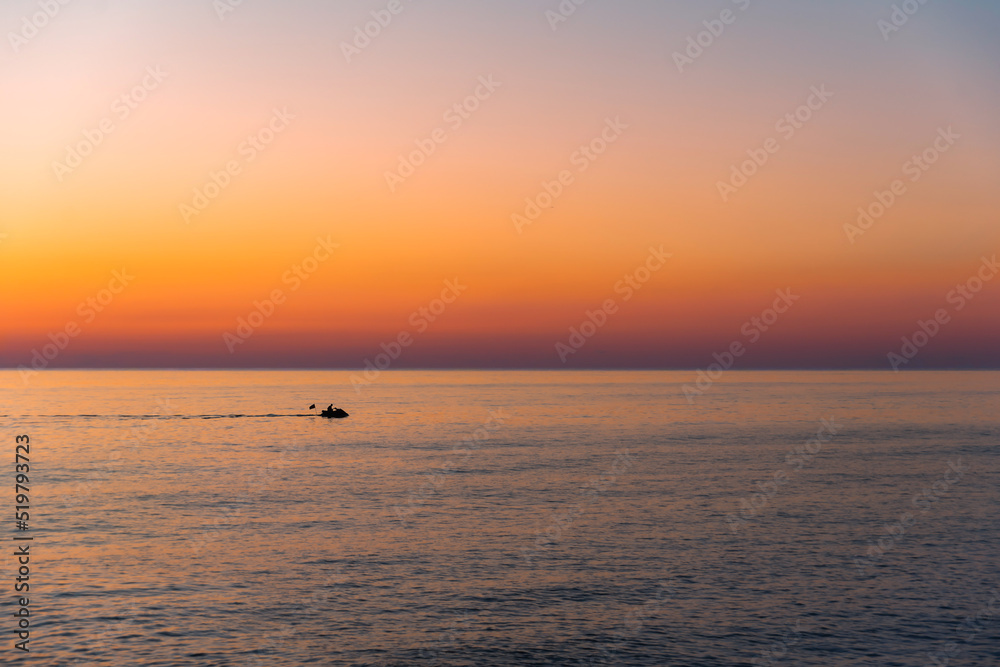 Silhouette of a jet ski of a sunset on the ocean