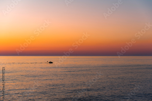 Silhouette of a jet ski of a sunset on the ocean