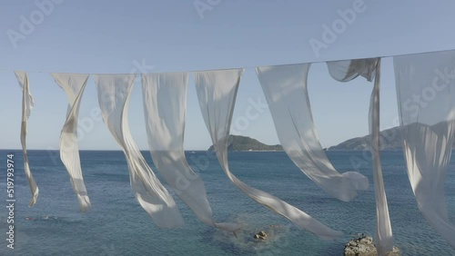 Time lapse of beautiful waving white lightweight fabric in the ocean background...