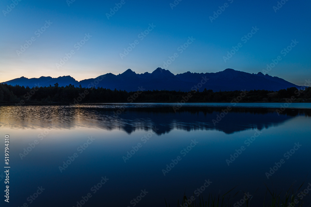 Sunset over a mountain lake and Tatras mountain in the background