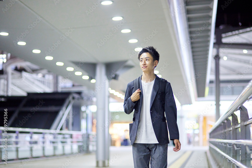 Fototapeta premium 若いビジネスマンと夜の駅