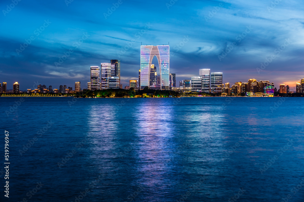 City skyline and modern commercial buildings in Suzhou at sunset, China.