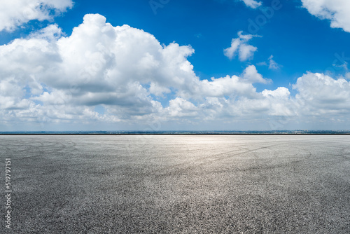 Empty asphalt road and city skyline with sky cloud scenery © ABCDstock