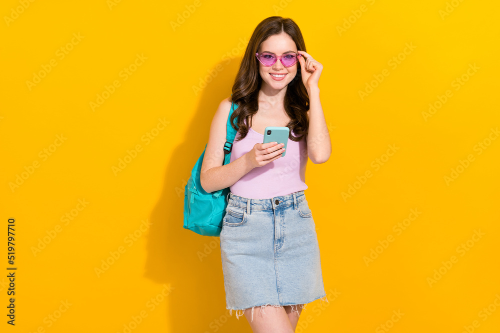 Photo of nice positive person hold telephone touch glasses isolated on yellow color background Photo of nice positive person hold telephone touch glasses isolated on yellow color background