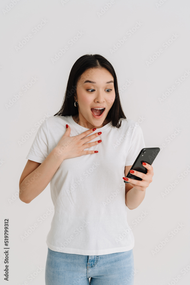 Asian surprised woman wearing t-shirt using mobile phone Asian surprised woman wearing t-shirt using mobile phone
