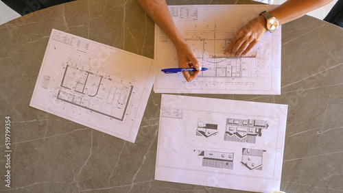 TOP DOWN: Female feng shui expert drawing energy lines on house building plan photo