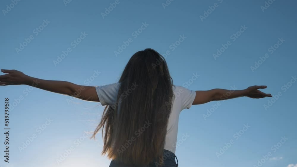 Happiness concept.young girl with her hair down, with her hands up, stands with her back raised her hands, enjoying blue sky, sun. Girl dreaming raising her hands up to sky, enjoying happiness. Happiness concept.young girl with her hair down, with her hands up, stands with her back raised her hands, enjoying blue sky, sun. Girl dreaming raising her hands up to sky, enjoying happiness.
