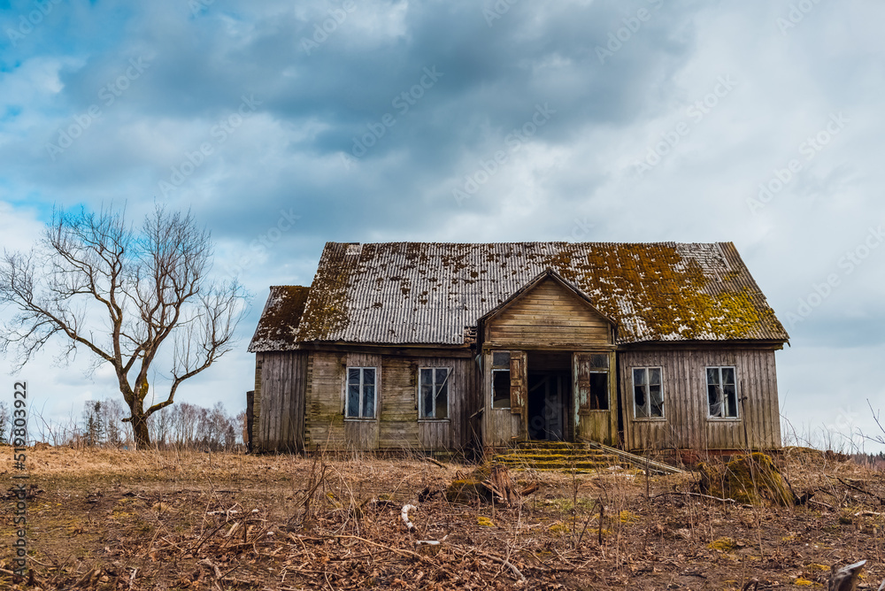 One old abandoned horror wooden house,dramatic stormy clouds with tree at autumn evening. One old abandoned horror wooden house,dramatic stormy clouds with tree at autumn evening.