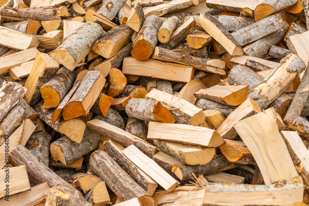A pile of stacked firewood, prepared for heating the house. Firewood for ready heating in winter.Chopped firewood.environment background. A pile of stacked firewood, prepared for heating the house. Firewood for ready heating in winter.Chopped firewood.environment background.